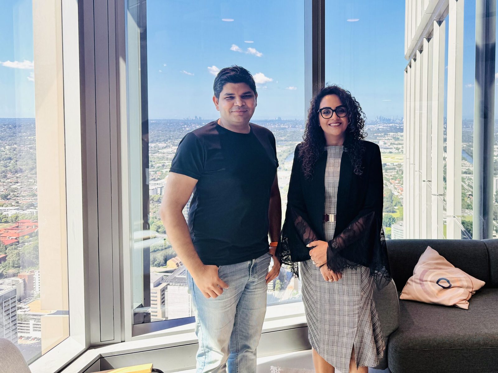 Leaders from PRIMA and JobGen.AI standing together in front of a city skyline